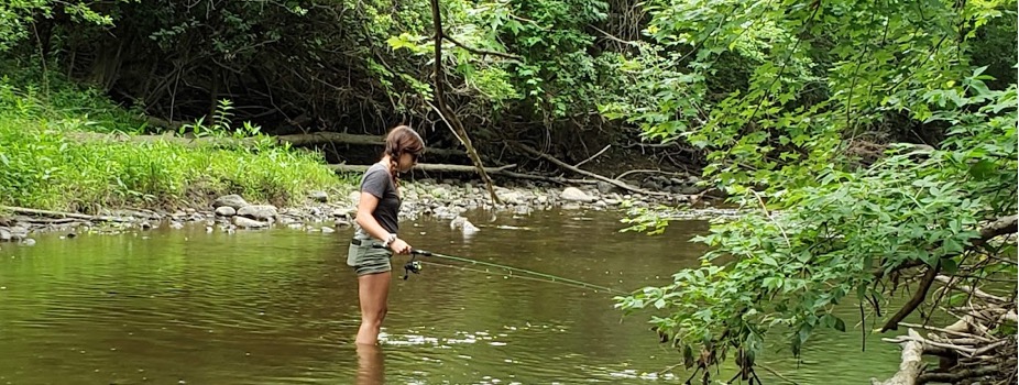 Michigan State University researcher Bailey Lorencen fishing for gobies in a Michigan river.