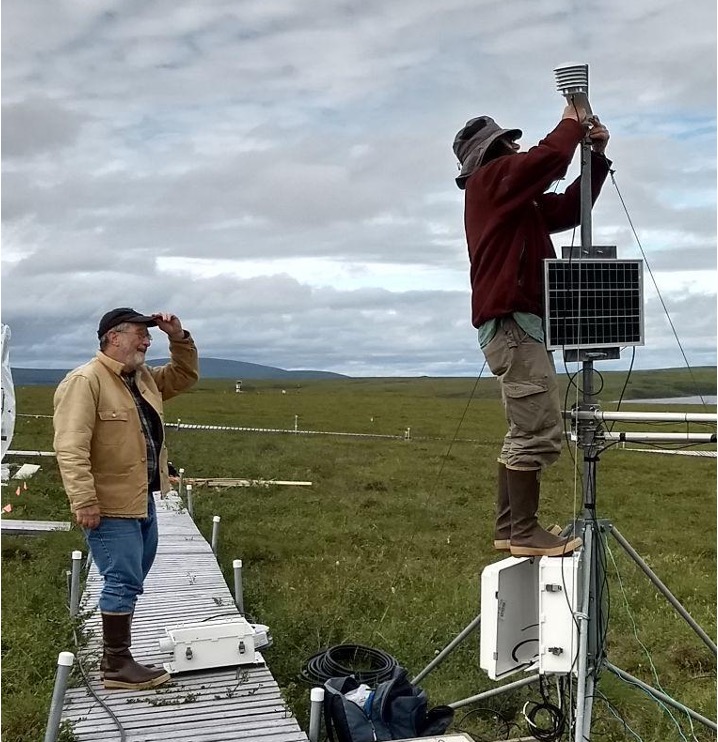 Gus (left) and Jim (right) set up a weather station to monitor air temperature and humidity on the tundra. 