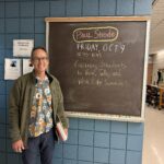 Paul Strode standing in front of chalkboard with his seminar title "Getting Students to Think, Talk, and Write Like Scientists".
